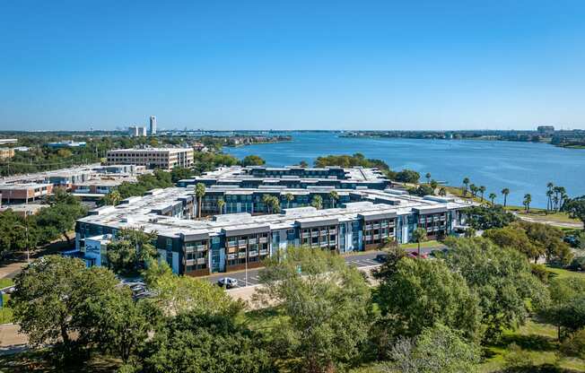 an aerial view of a building with a lake in the background