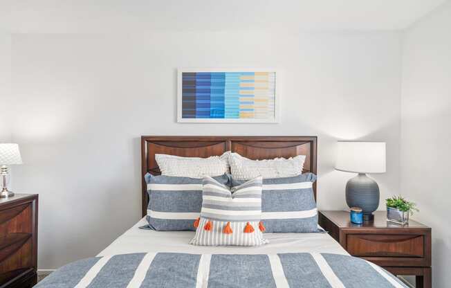 a bedroom with a bed with blue and white pillows