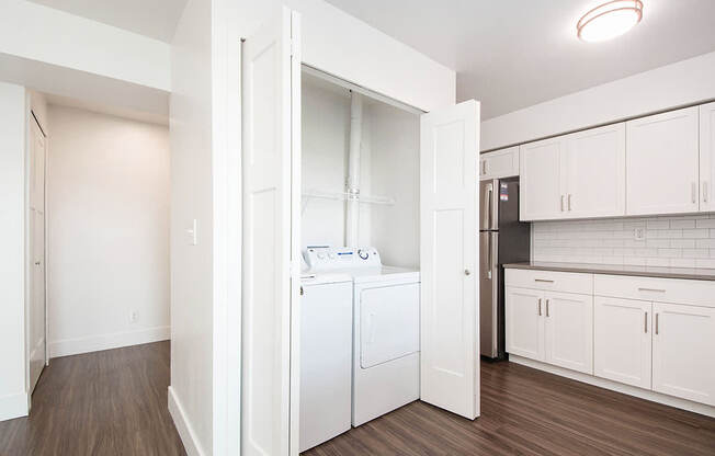 A white laundry room with a washer and dryer at The Crossings Apartments, Grand Rapids, MI, 49508