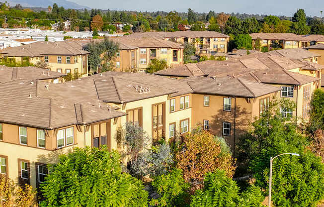 A large apartment complex with multiple buildings and trees in the foreground.