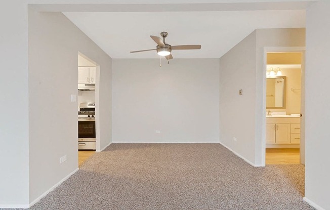 an empty living room with a ceiling fan