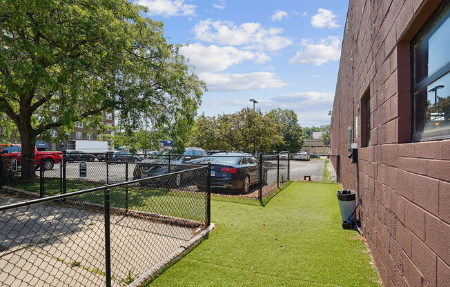 a yard with a chain link fence and a parking lot