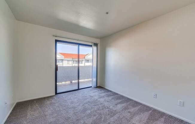 a bedroom with a sliding glass door and carpeted floor