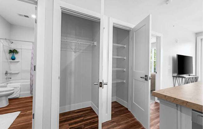 A white bathroom with a walk-in shower and a wooden floor.