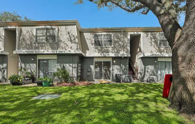 A tree is next to a building with a red mailbox.