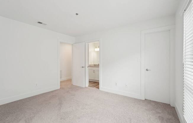 A white room with a carpeted floor and two doors.