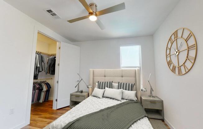 a bedroom with a bed and a large clock on the wall