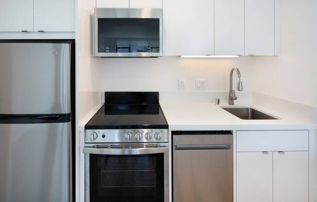 a kitchen with white cabinets and stainless steel appliances