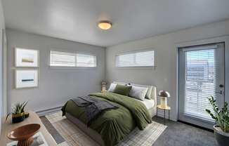 A bedroom with a bed, nightstand, and window.