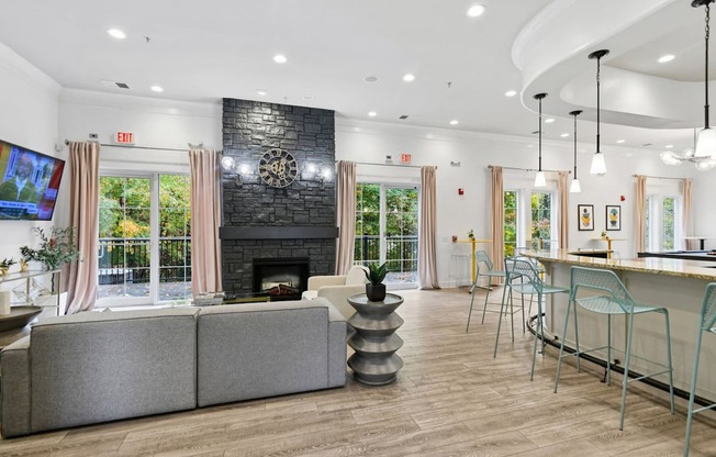 A living room with a grey couch, a fireplace, and a TV.