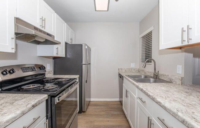 A kitchen with a black stove top oven and a black refrigerator.