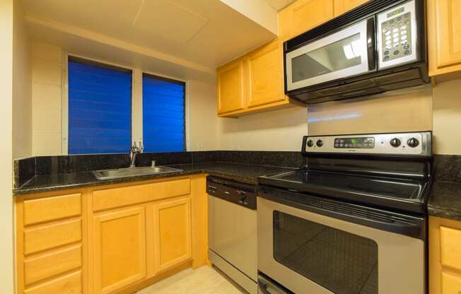 Napili Towers kitchen area with appliances, cabinets, and counters