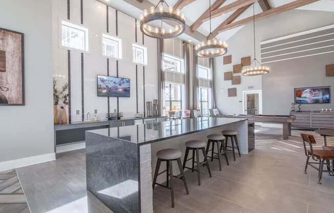 a long bar with stools in a living room with large windows