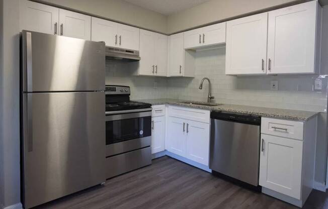 A kitchen with a stainless steel refrigerator, oven, and dishwasher at The Madison Apartments and Townhomes, Lawrenceville