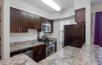 kitchen with espresso cabinetry, breakfast bar and window at fairway park apartments in washington dc