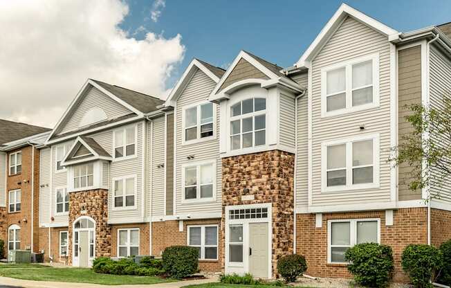 A row of townhouses with a mix of brick and siding exteriors
