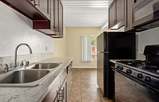 a kitchen with a sink a stove and a refrigerator