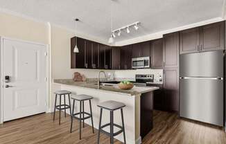 A kitchen with a white door and a counter with a bowl of fruit on it.