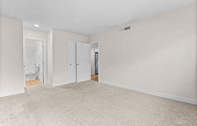 an empty living room with white walls and a carpeted floor