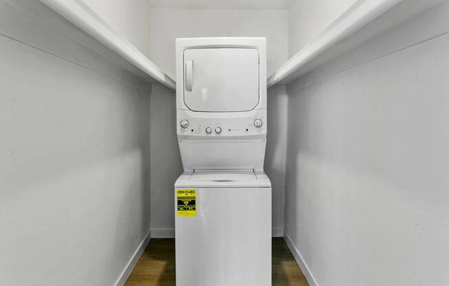 A white toilet with a yellow sticker on the side is in a small room.