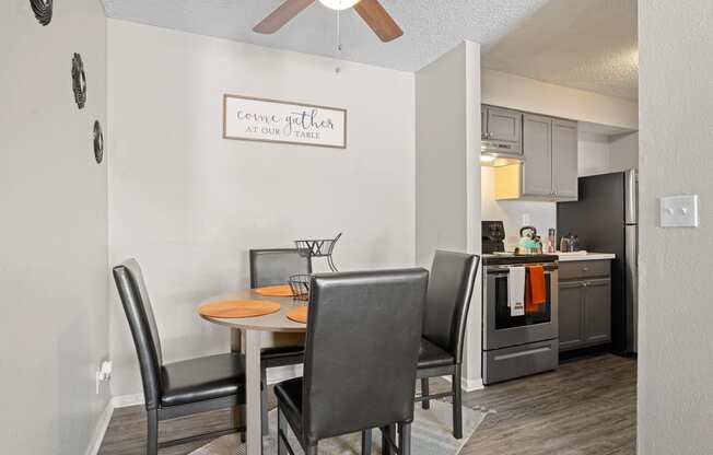 a dining area with a table and chairs and a kitchen