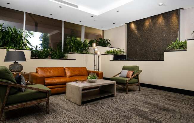 A living room with a brown couch, a green chair, and a grey coffee table.
