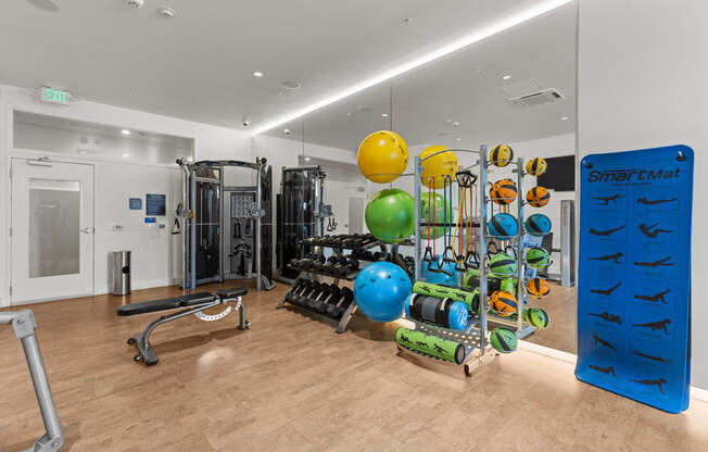 a gym with weights and other exercise equipment on a wooden floor