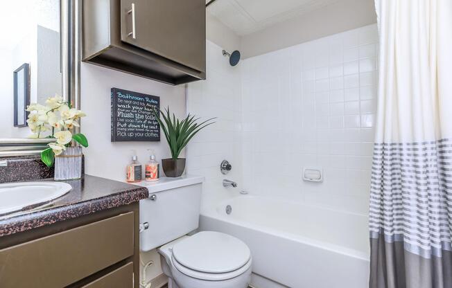 furnished bathroom with a white and black shower curtain