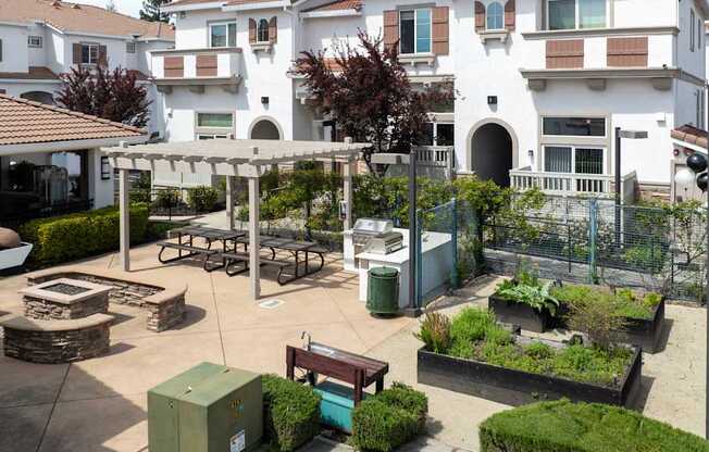 A courtyard with a bench, a table, and a fence.