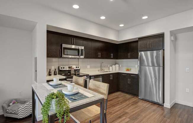 A modern kitchen with dark brown cabinets and stainless steel appliances.