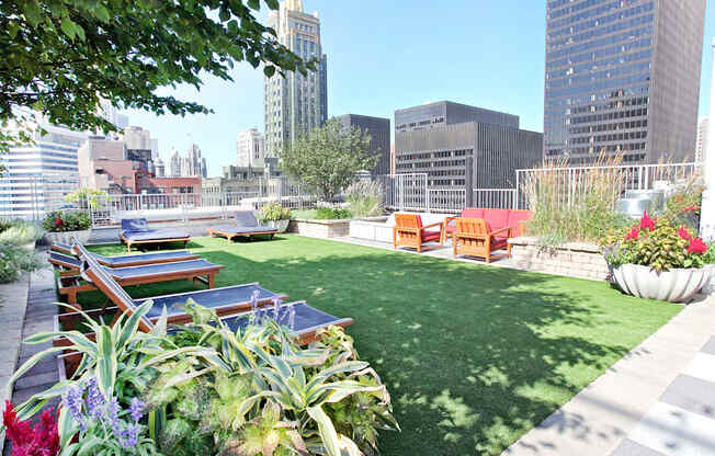a roof top garden with a lawn and picnic tables