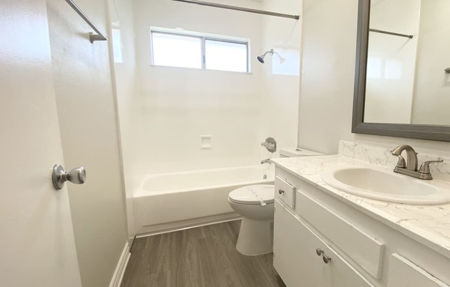 an empty bathroom with a sink toilet and shower