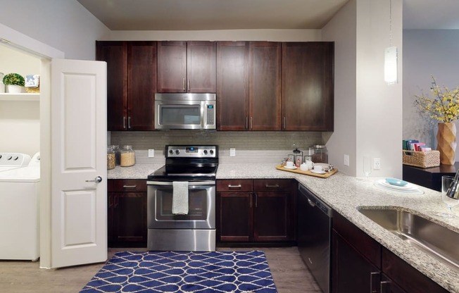 a kitchen with dark wood cabinets and a blue rug