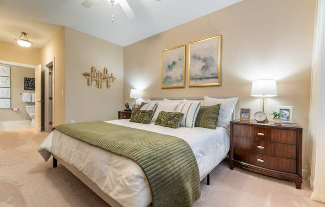 A bedroom with a large bed and a ceiling fan.