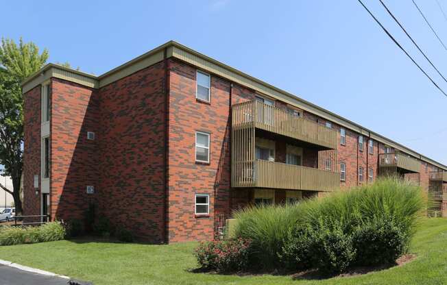 an exterior view of a red brick apartment building with balconies