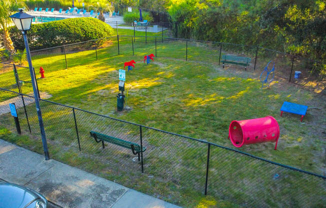 a playground in a park with benches and a fence