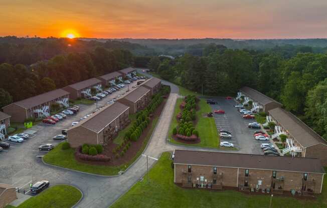 an aerial view of a parking lot and buildings at sunset