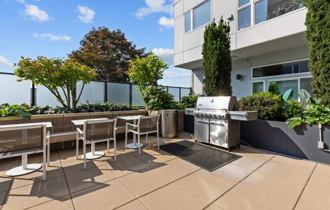 a patio with tables and chairs and a grill