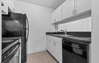 a kitchen with white cabinets and black appliances