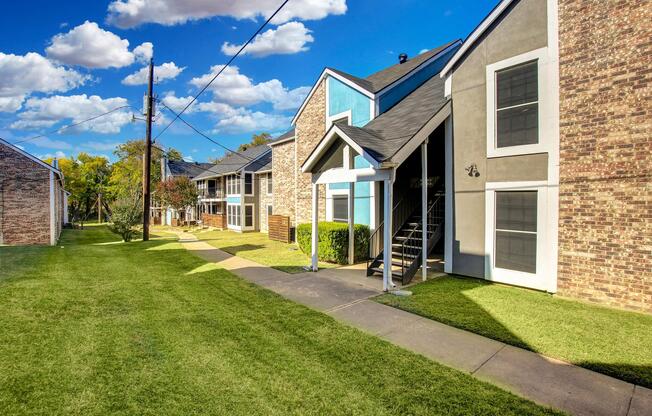 a large brick building with grass in front of a house