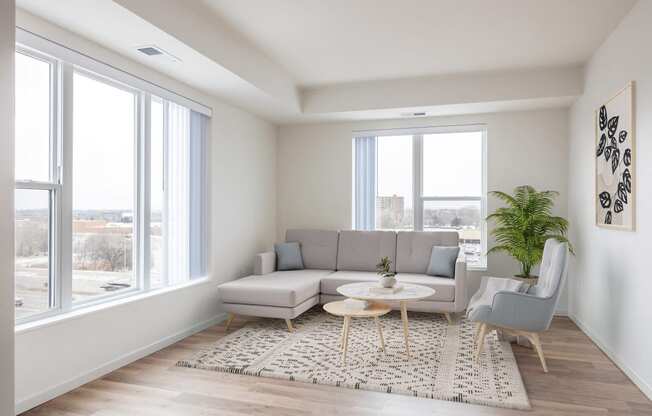 a living room with a gray couch and a rug and large windows