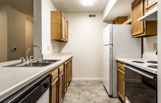 an empty kitchen with a sink and a refrigerator at Pheasant Run in Lafayette, IN 47909