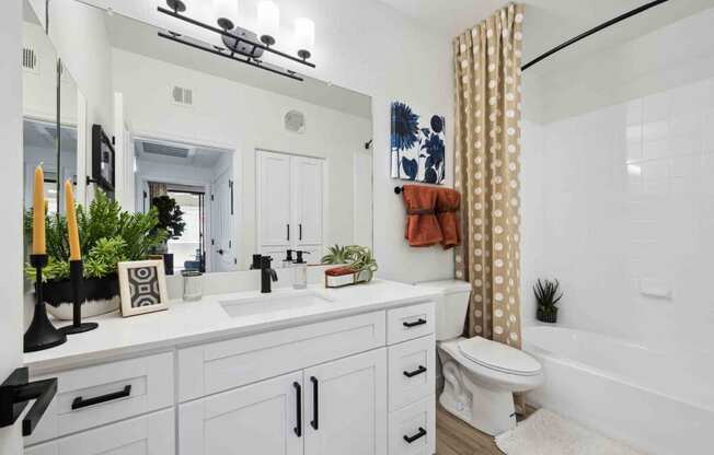 a bathroom with a white sink and toilet next to a bathtub with a shower curtain