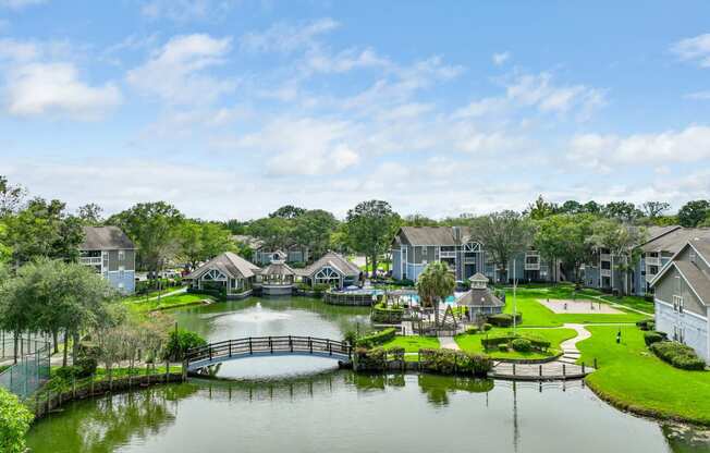 an aerial view of a lake with a bridge and houses in the background