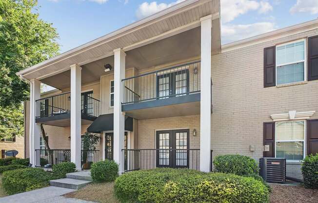 A two-story apartment building with a balcony on the second floor.