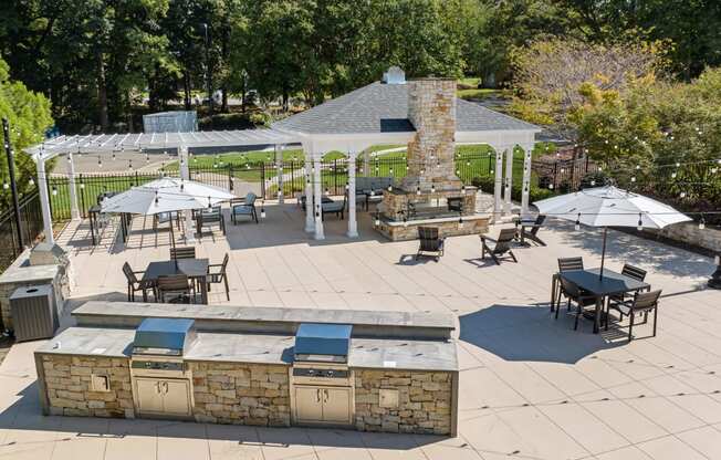 a patio with a grill and tables with umbrellas at View at Lake Lynn, North Carolina, 27613