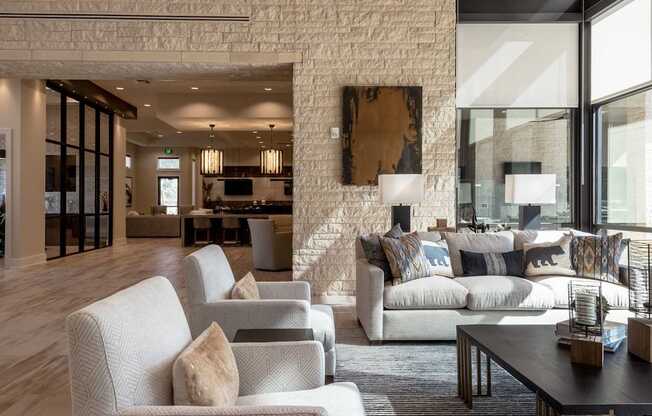 A living room with a white brick wall and a large abstract painting above a sofa.