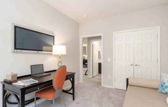 a living room with a desk and a television