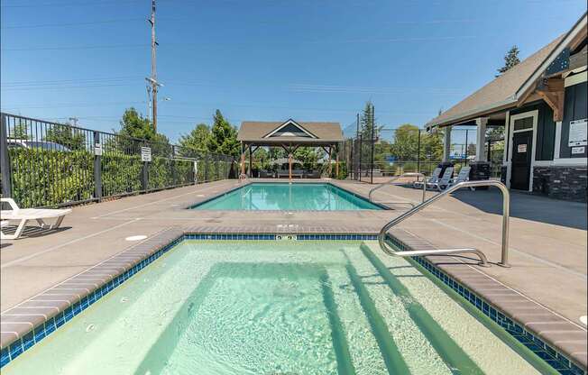 A pool with a diving board and a small building in the background at Forestplace Apartment Homes, Forest Grove, OR