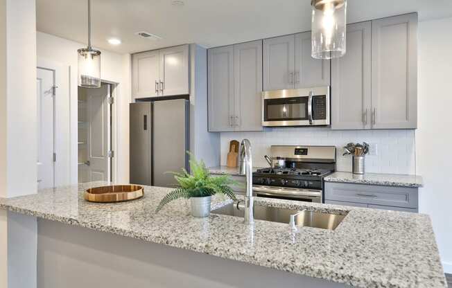 a kitchen with grey cabinets and a granite counter top